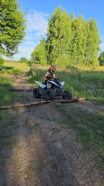 Quad na wąskiej polnej dróżce wśród zieleni