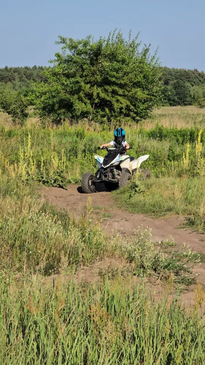 Quad na wąskiej ścieżce wśród wysokich traw