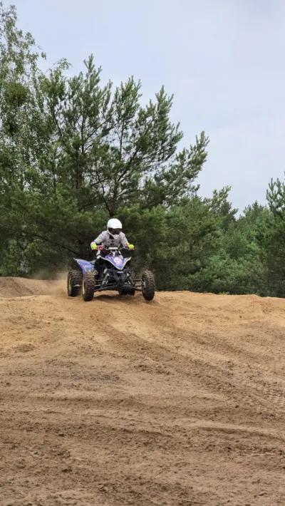 Biały quad na szczycie piaszczystego nasypu