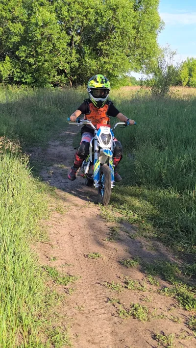 Motocykl crossowy na ścieżce wśród wysokich traw