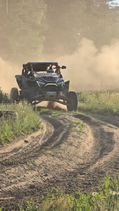 Buggy w chmurze kurzu na piaszczystej trasie