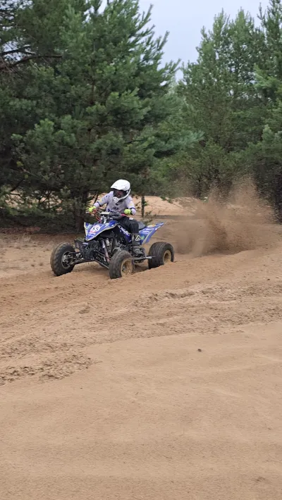 Quad na piaszczystym torze, spod kół unosi się pył